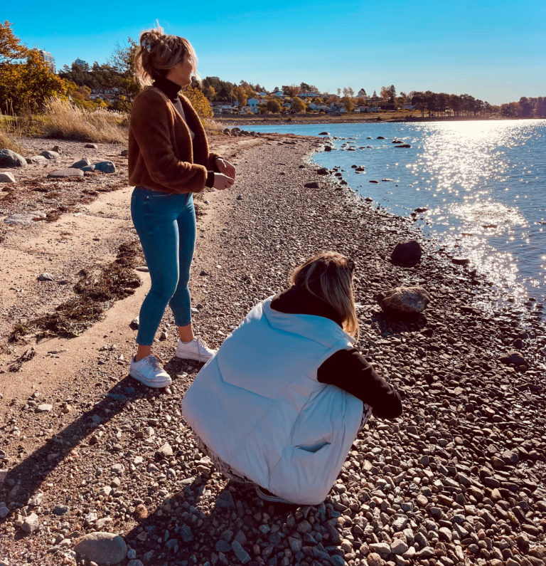 två tjejer på surfvikens strand på hösten