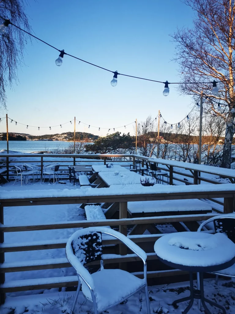 Snön ligger på uteserveringen och solen skiner.